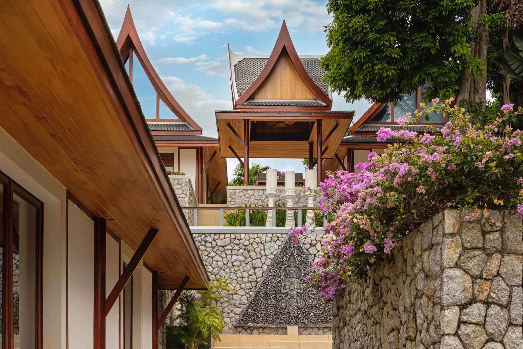 Architectural detail of the estate's Thai gables and carved stone relief