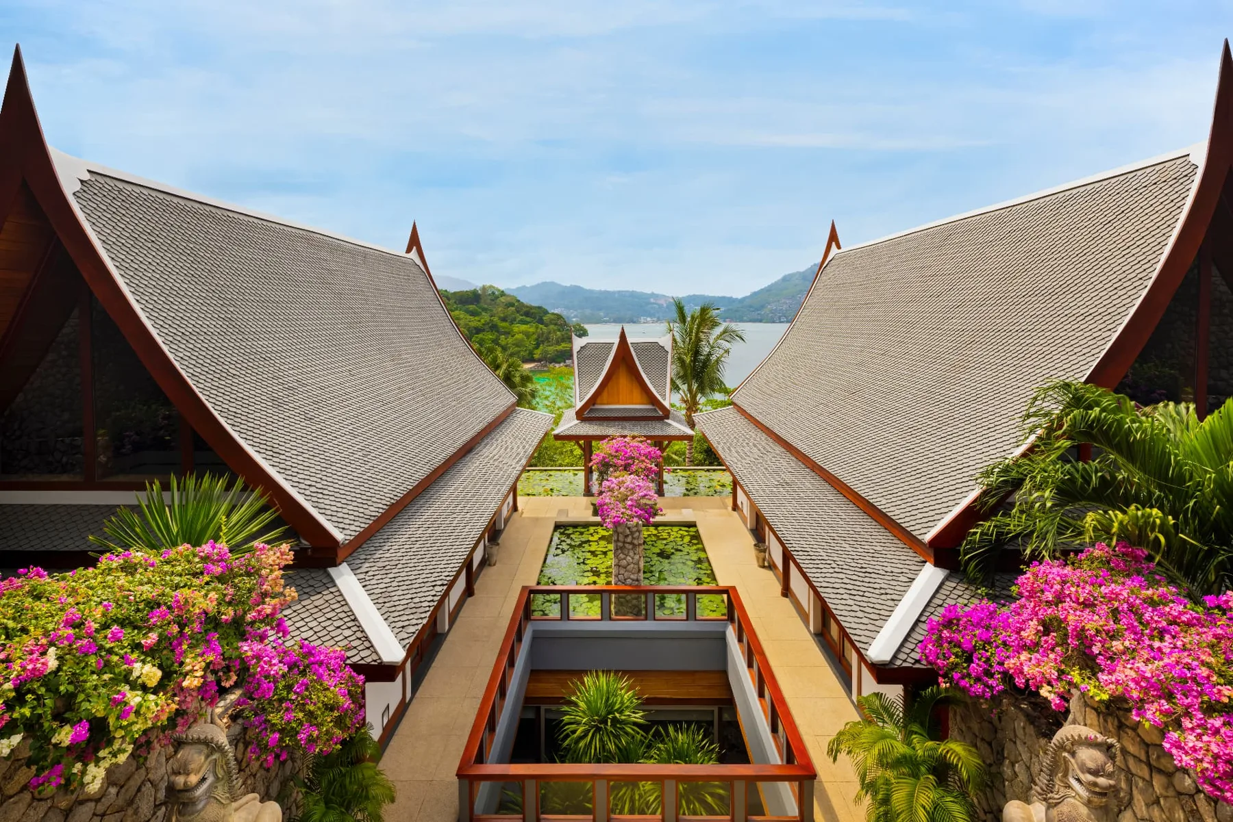 Overhead view between the estate's Thai gabled roofs to the lotus pond and sea