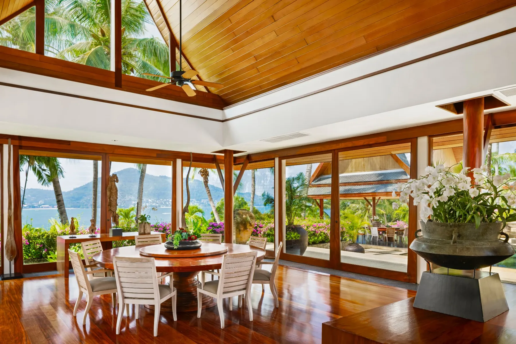 Indoor dining pavilion with round teak table and panoramic ocean views