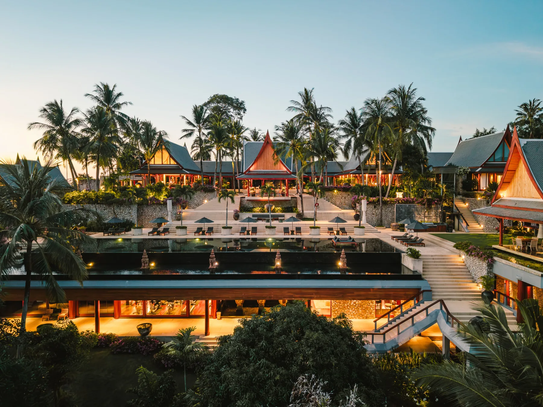 Evening view across the pool terrace to the estate's main pavilions